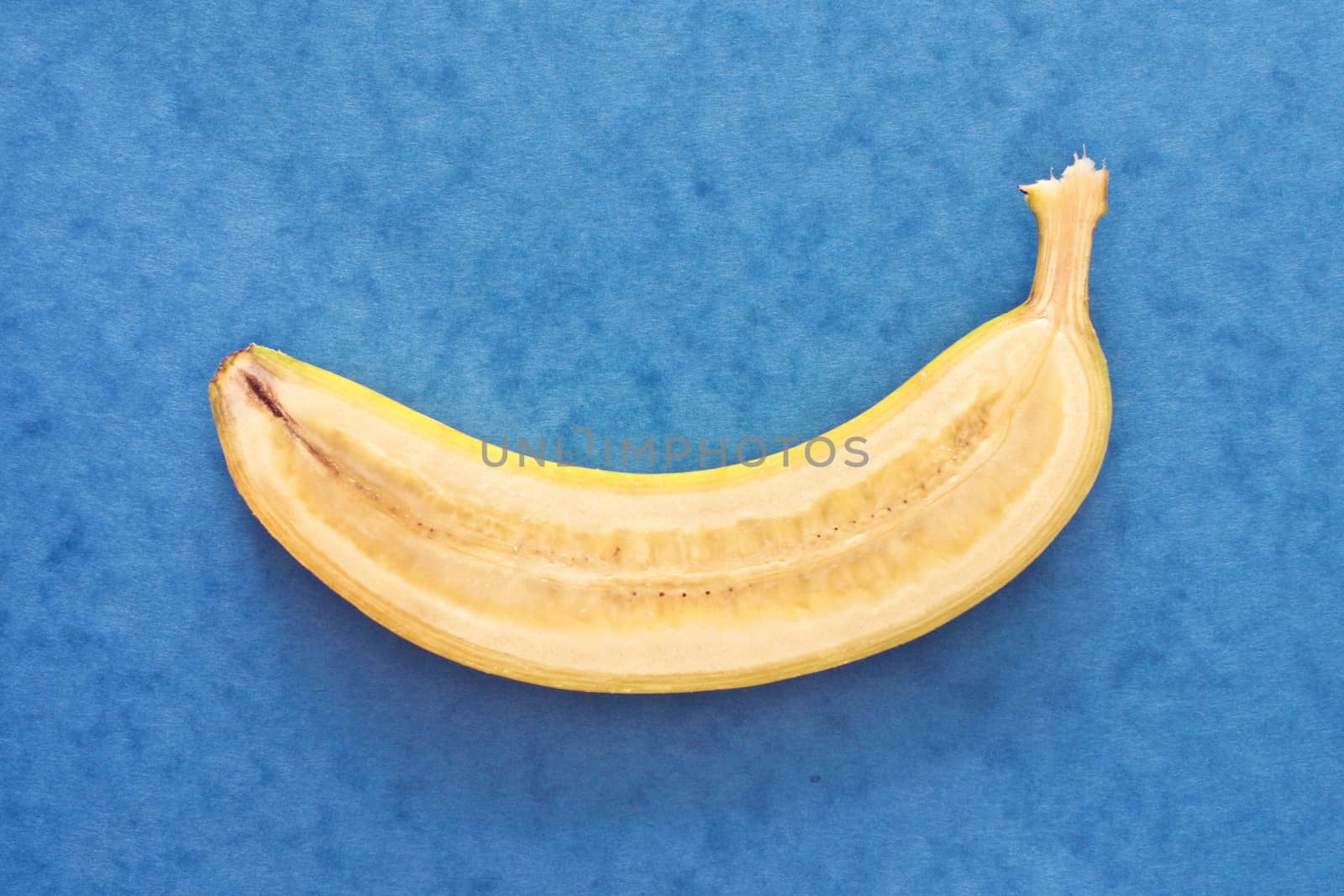 Slice of a fresh banana on a blue background