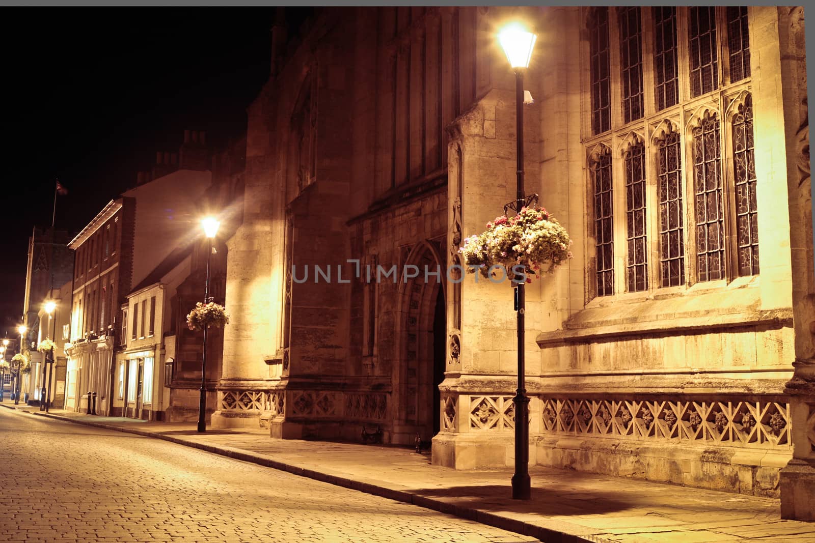 Medieval cathedral and steet at night with street lighting