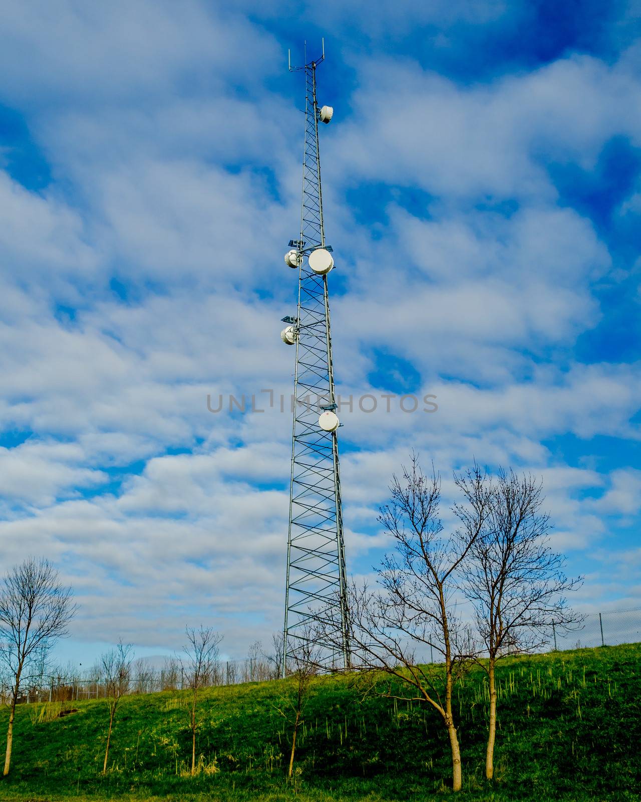 Telecommunication Tower against a cloudy blue  sky.