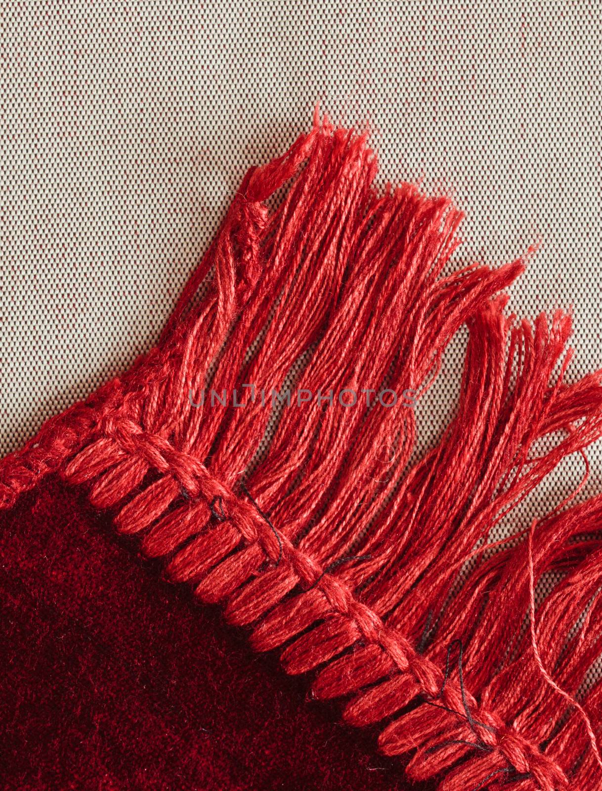 Corner of a red rug showing tassles