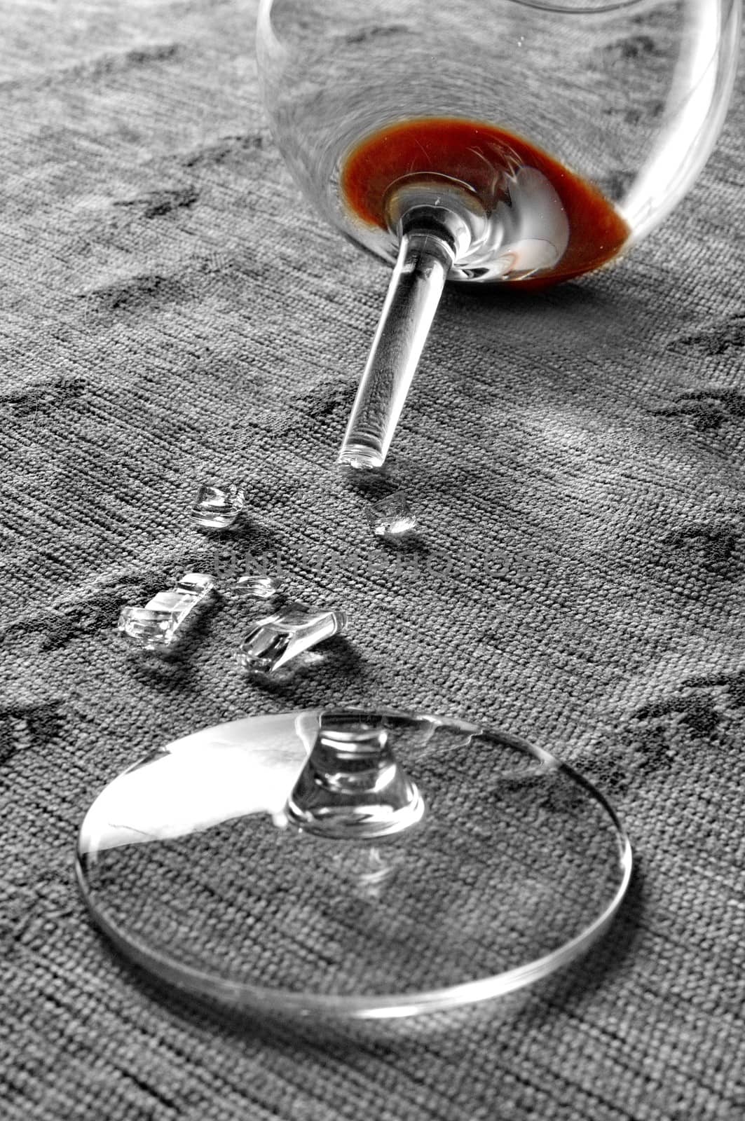 Red wine in broken glass half desaturated by anderm