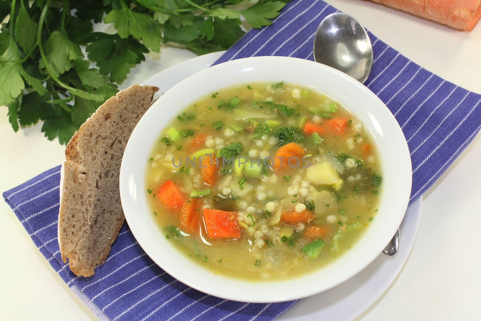 a bowl of colorful barley soup in front of white background