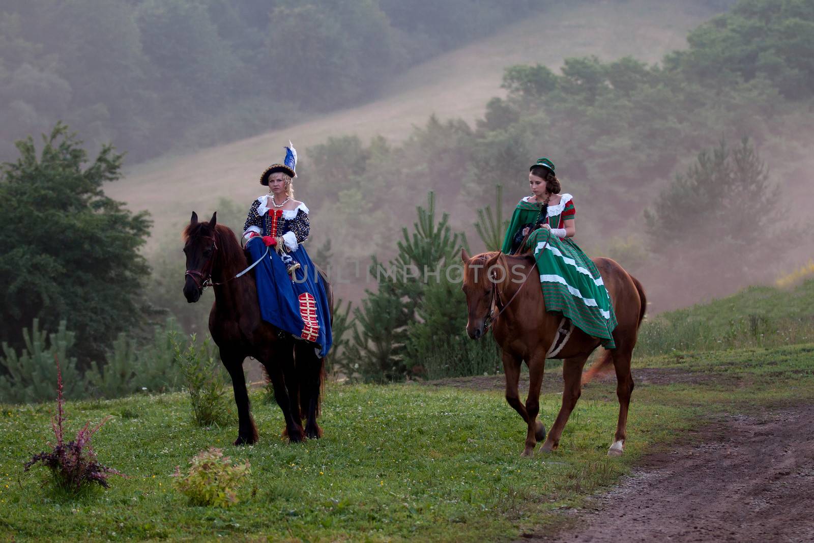Two women in the royal baroque dress, riding in the fog