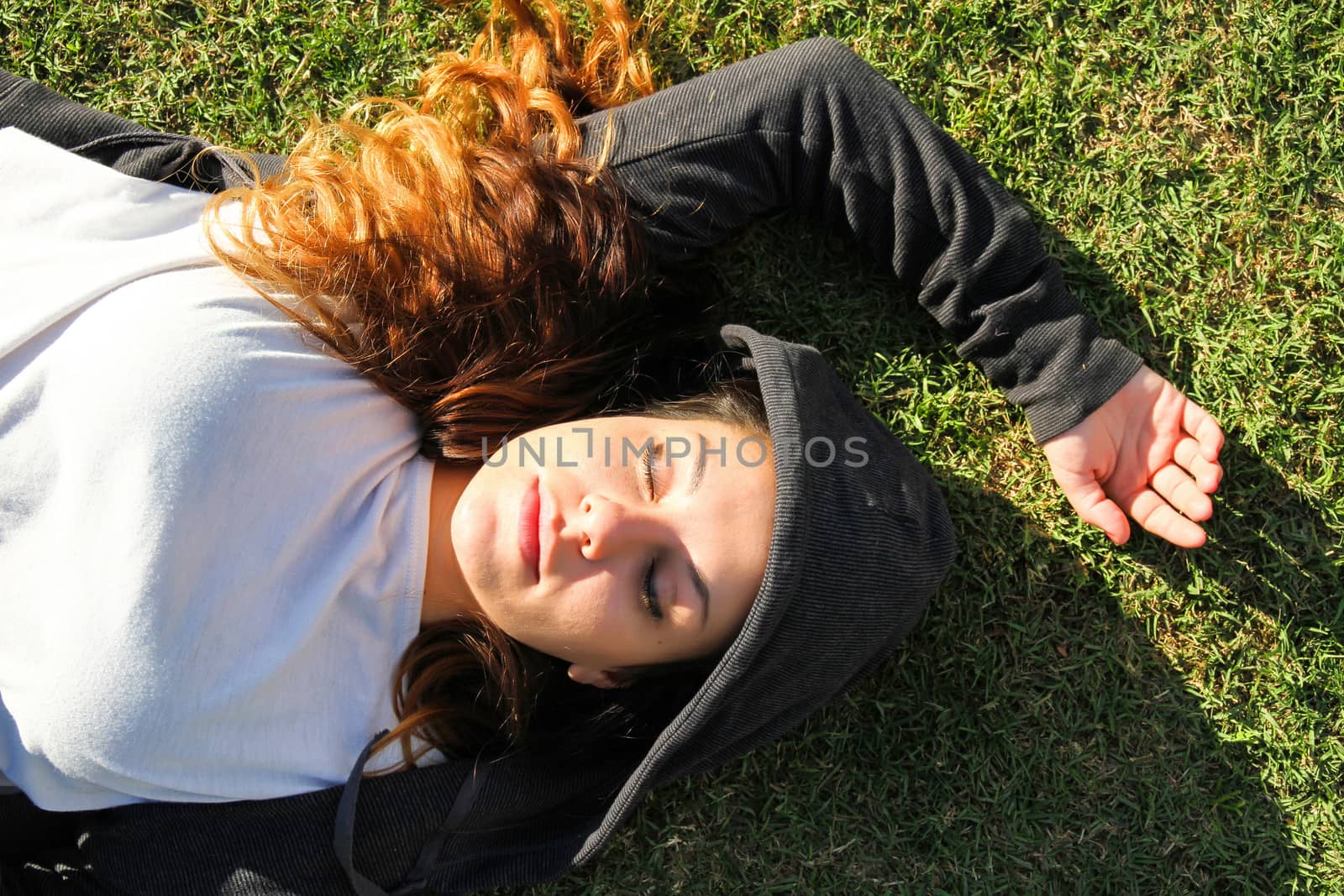 A young woman enjoying the sunlight in the Park.			
