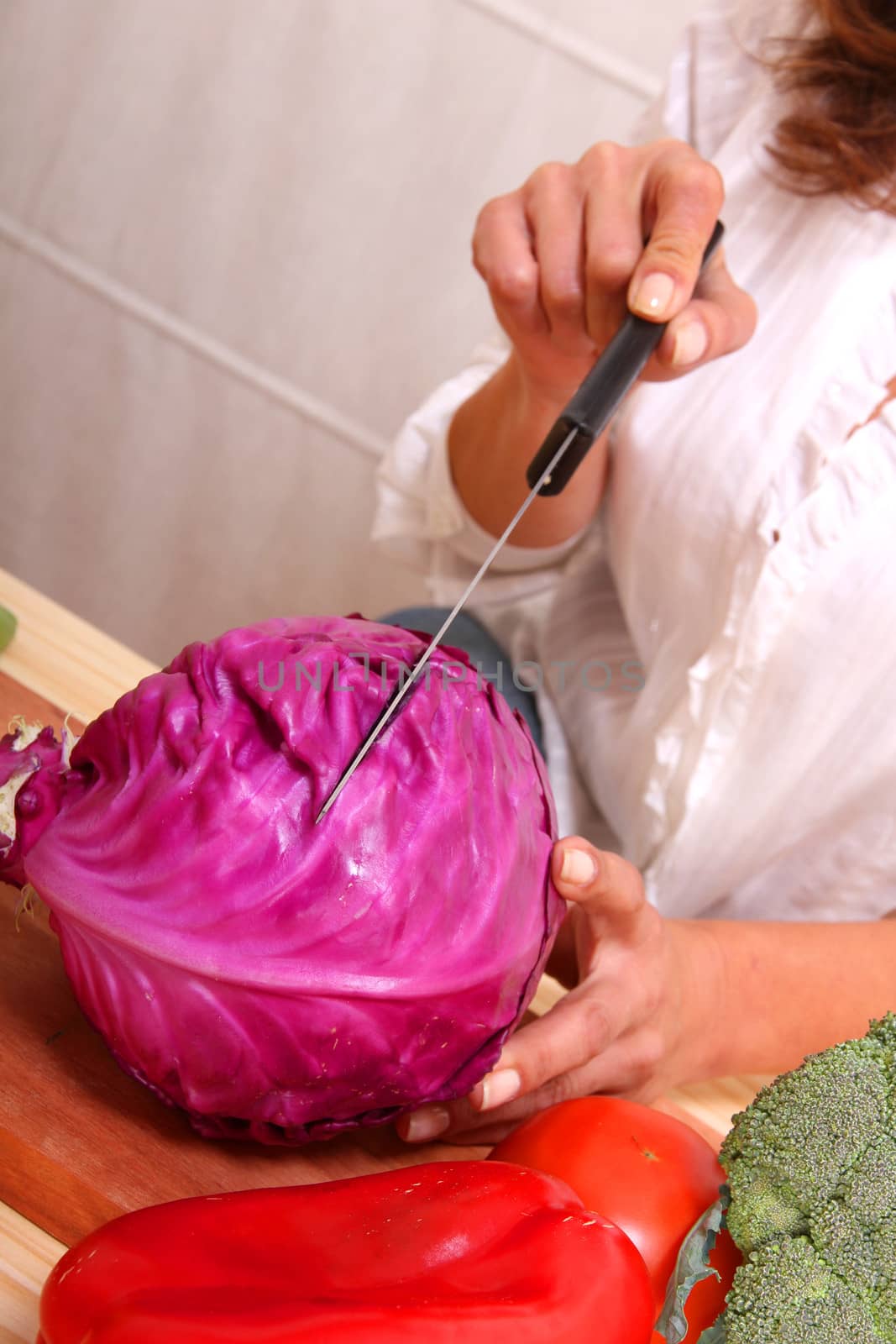 A beautiful mature woman cutting vegetables in the kitchen.