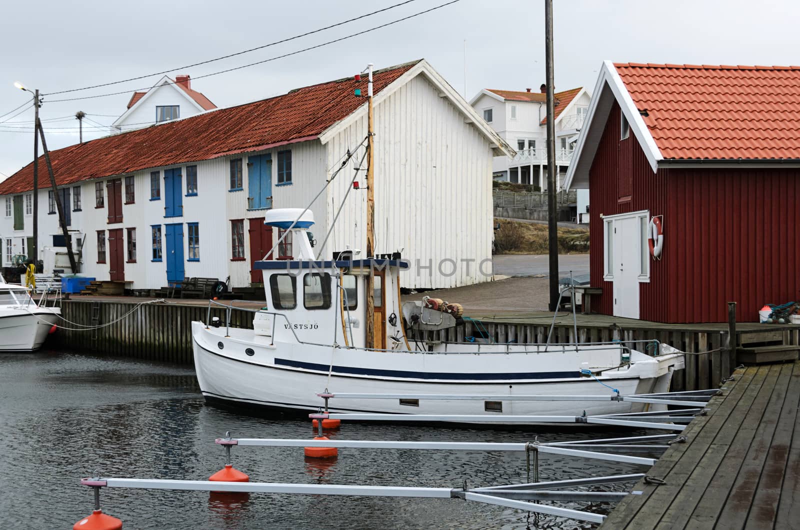 a lone fishing boat in its harbor a winter day