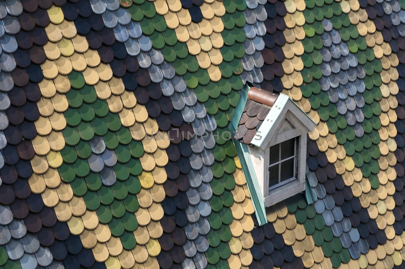 Detailed view of colorful roof shingles and window.