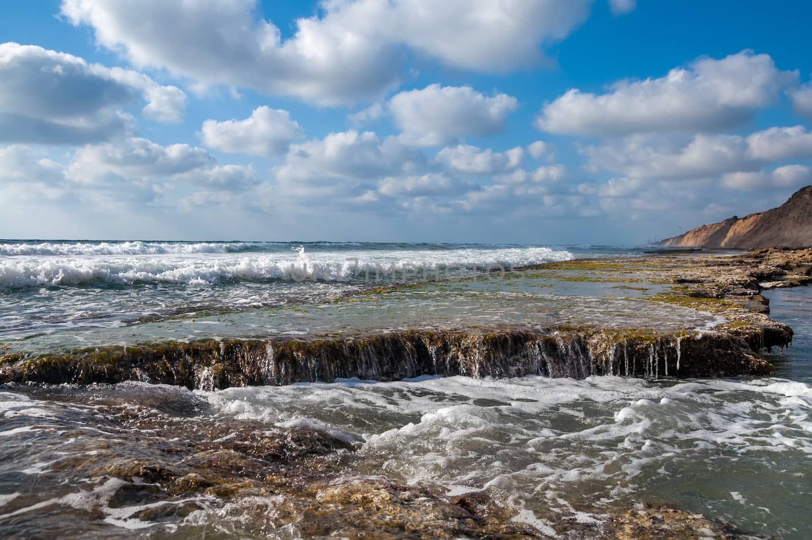 Landscape of the rocky coast, blue cloudy sky background