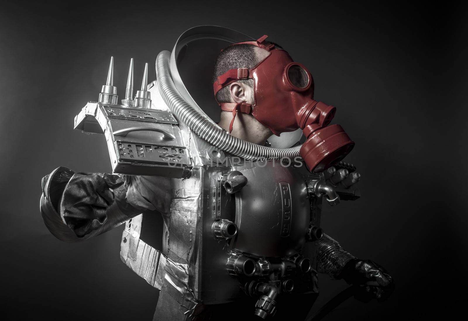 Astronaut with red gas mask on a black background with huge weapon.