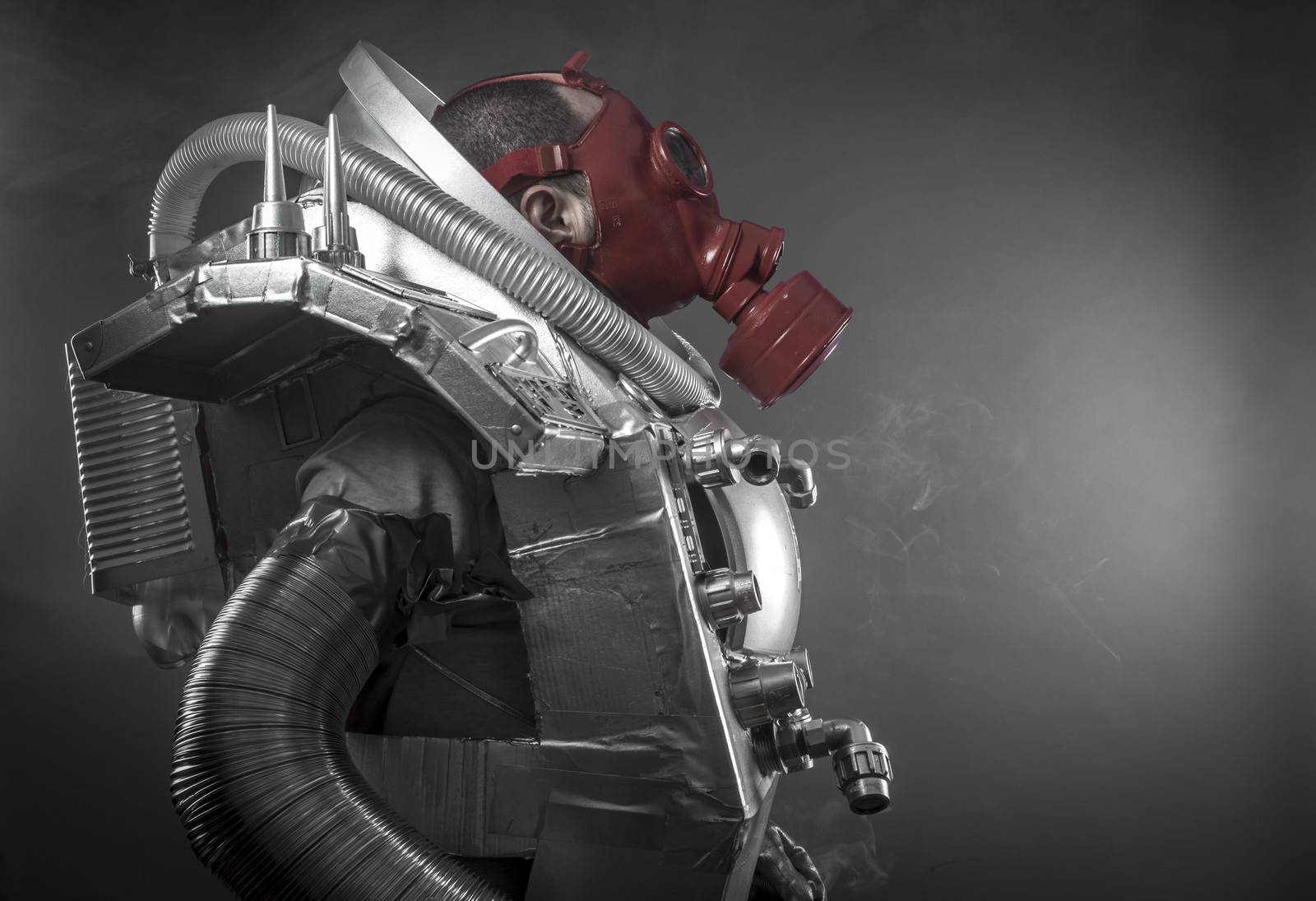 Astronaut with red gas mask on a black background with huge weapon.