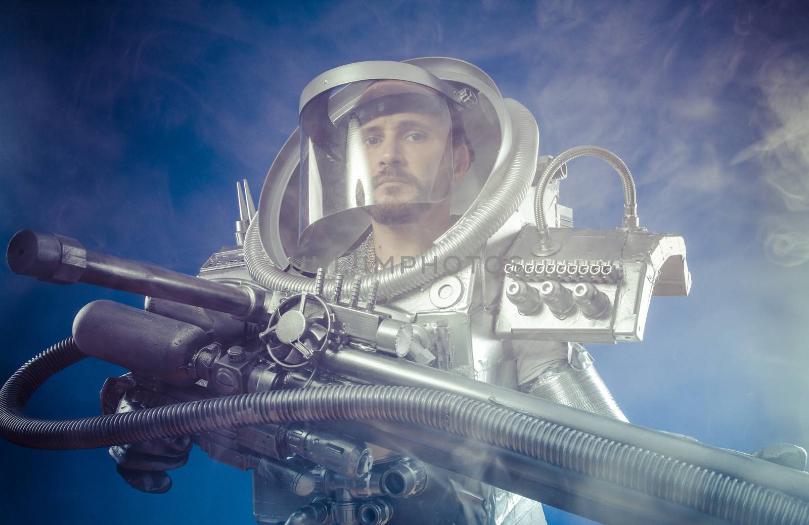 Astronaut warrior on a black background with huge weapon.