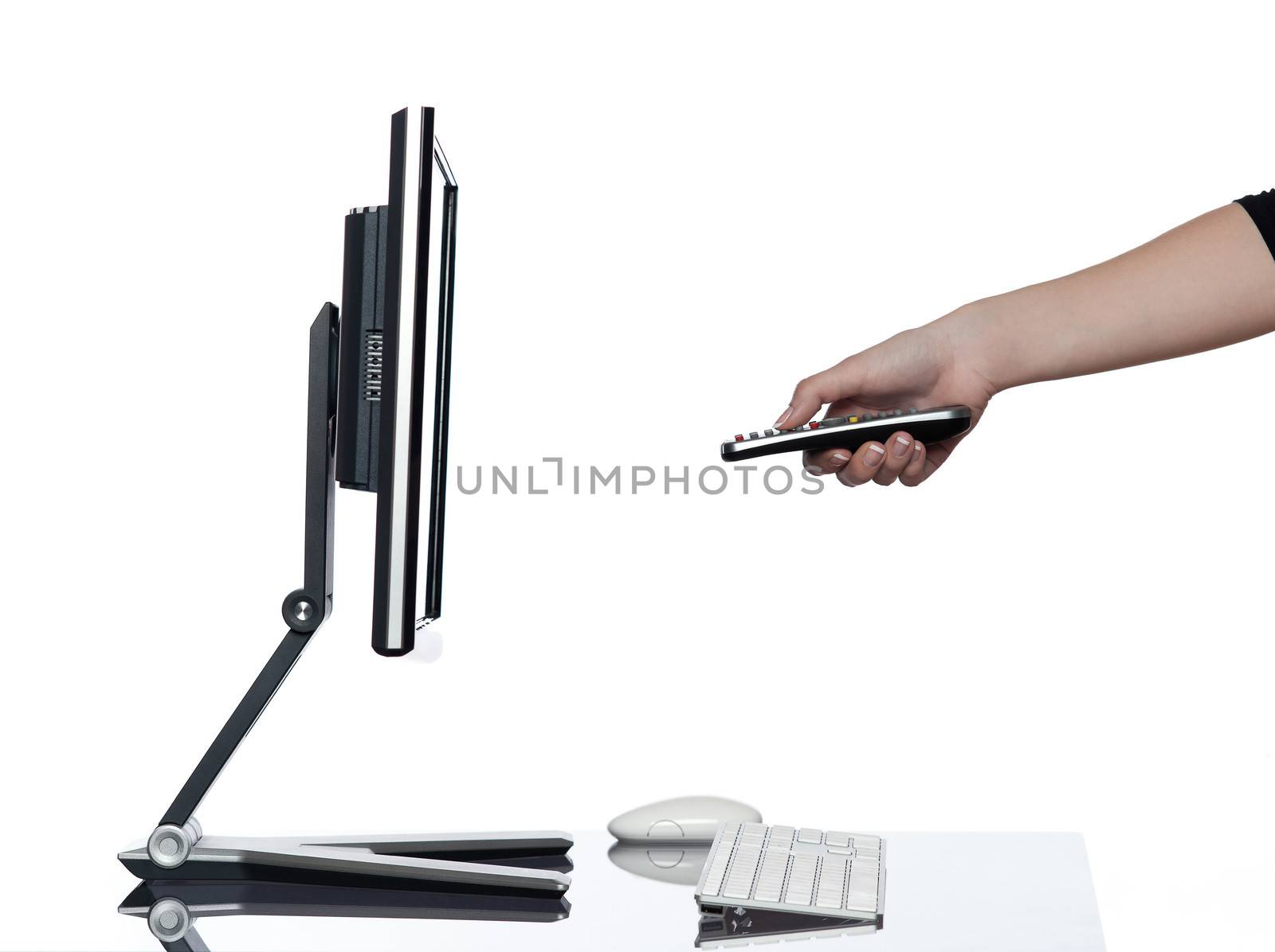 human hand pointing remote control and a computer display monitor on isolated white background expressing switch off pause concept