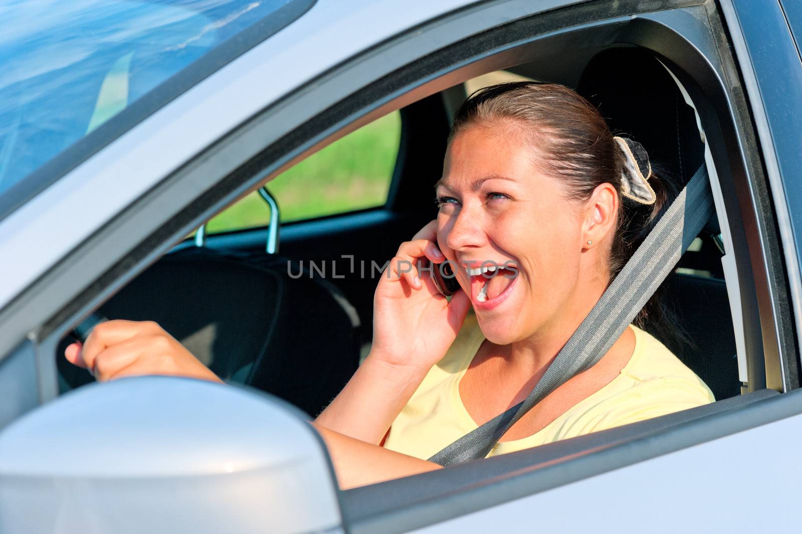 beautiful girl behind the wheel with phone laughing by kosmsos111