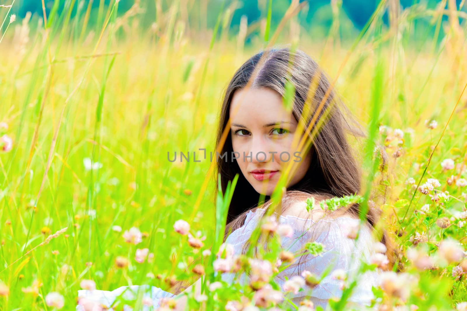 girl in a white sundress lying on green grass