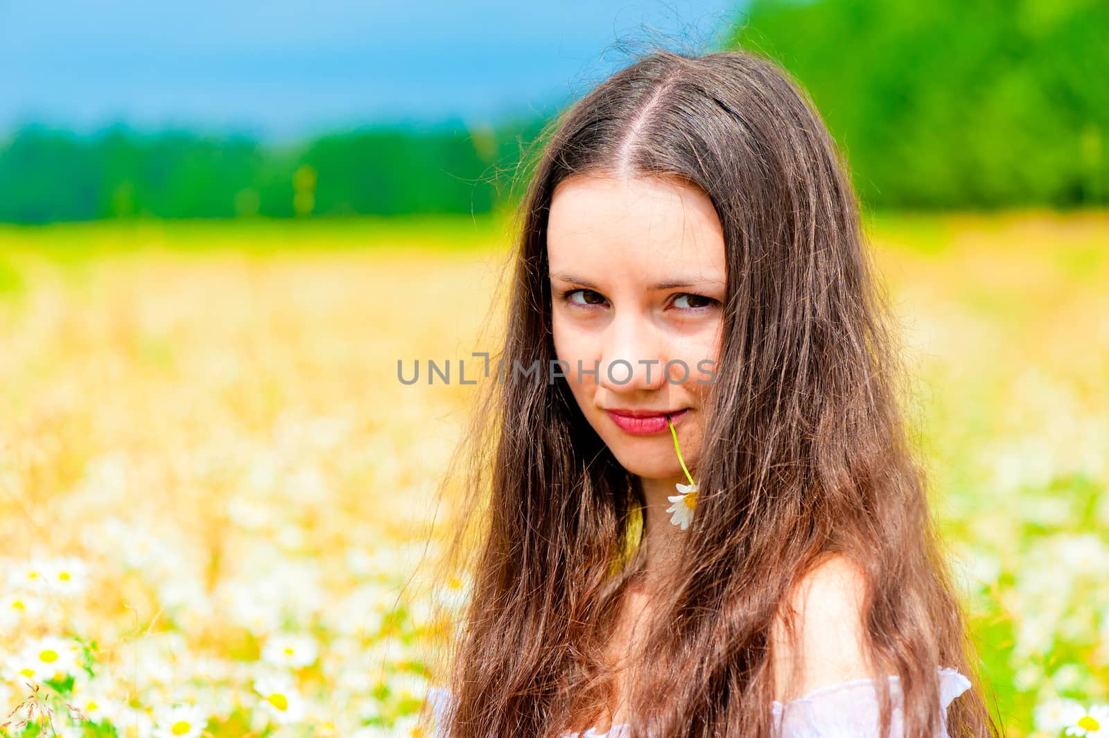 Portrait of a young beautiful girl with daisy flower