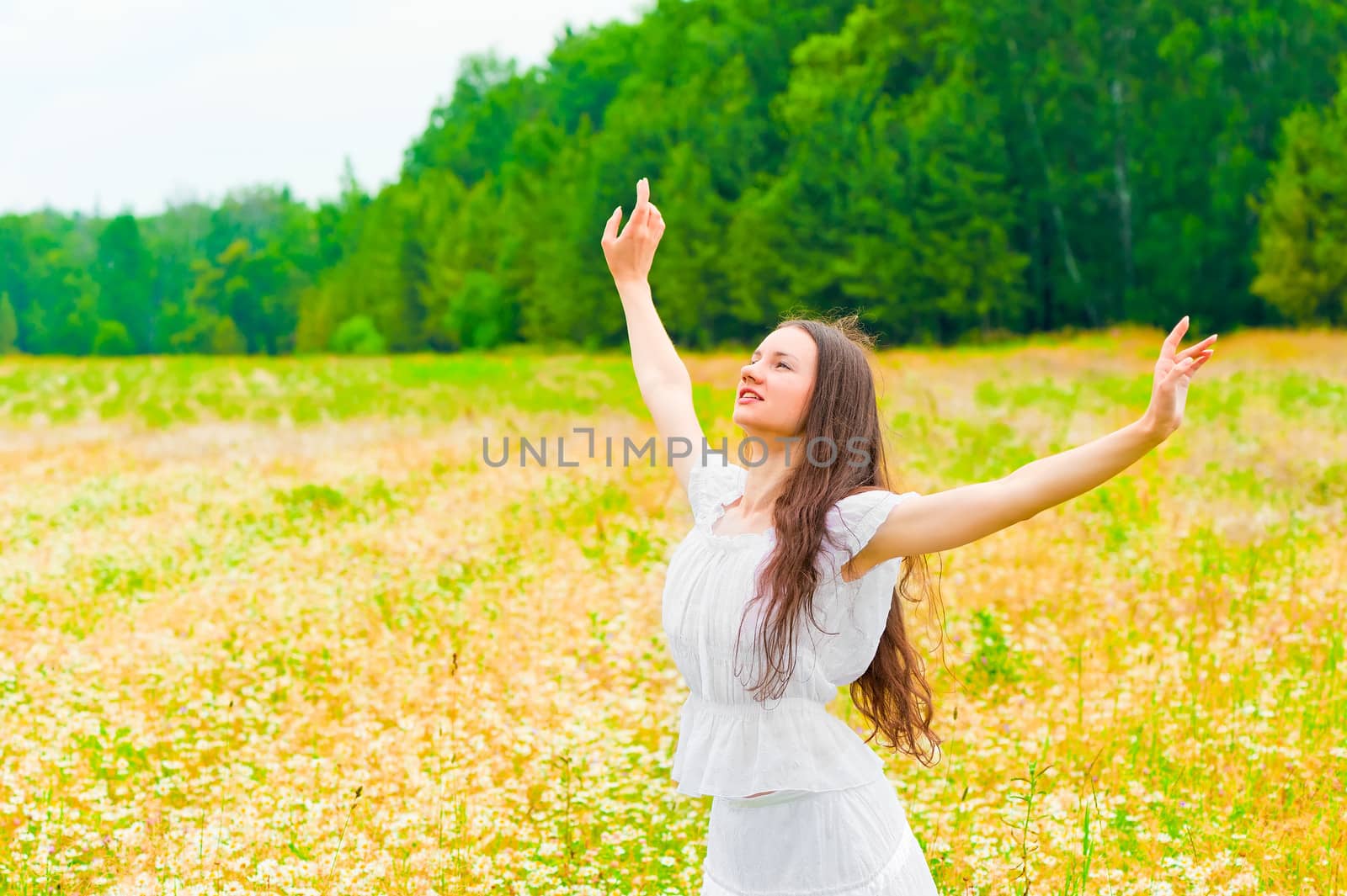 brunette with a flower field with arms outstretched to the sides