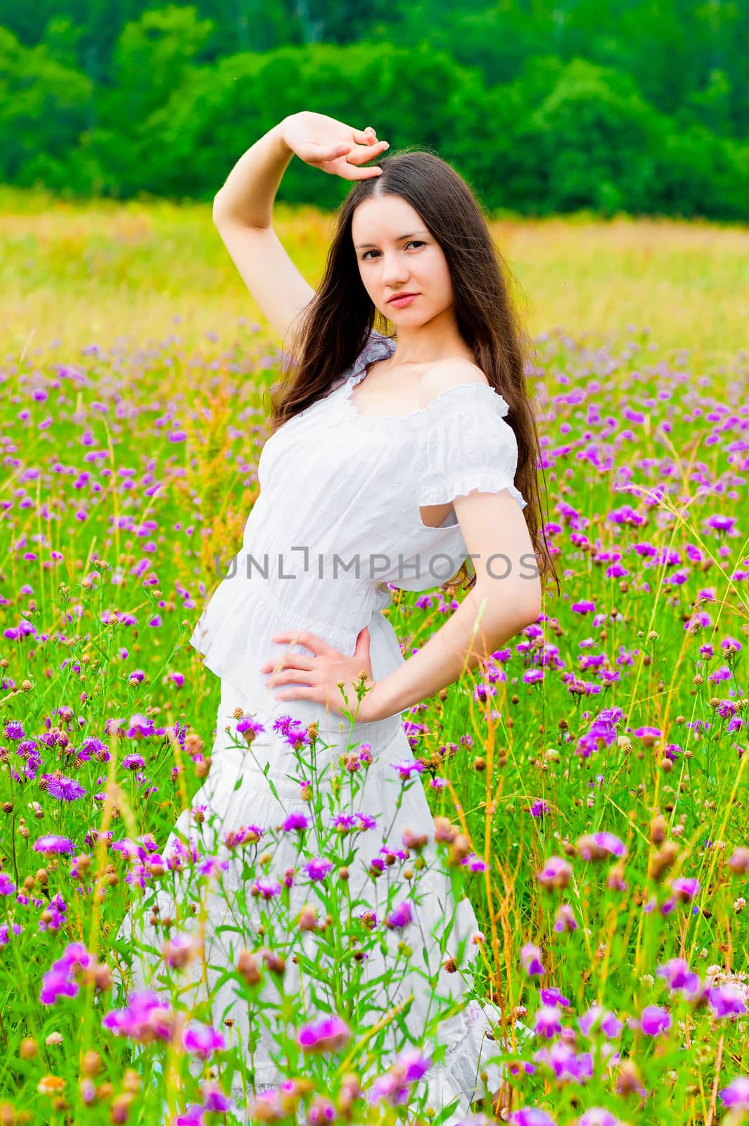 beautiful woman posing in a field with flowers