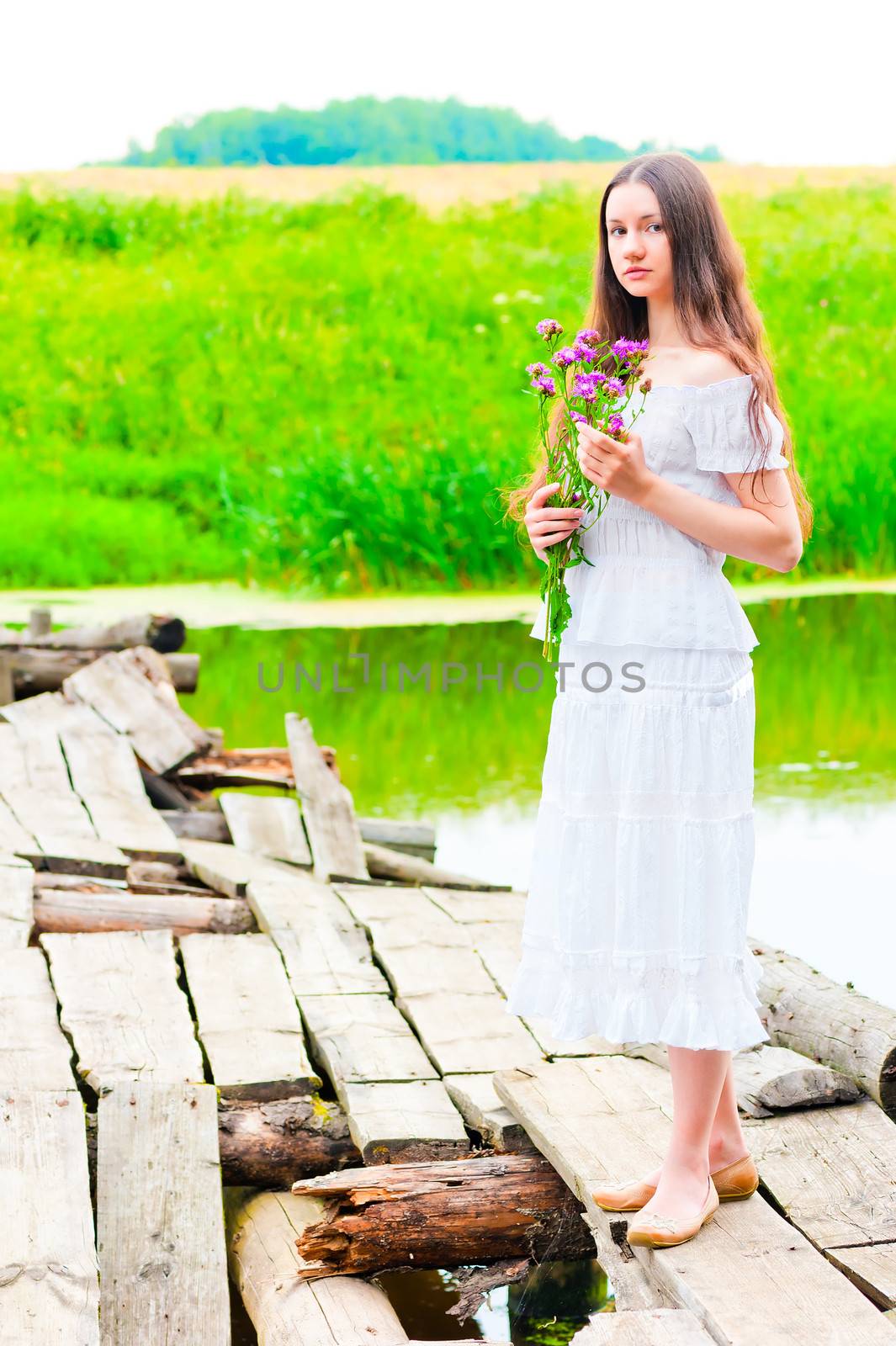 girl on an old wooden bridge with a bouquet of flowers by kosmsos111