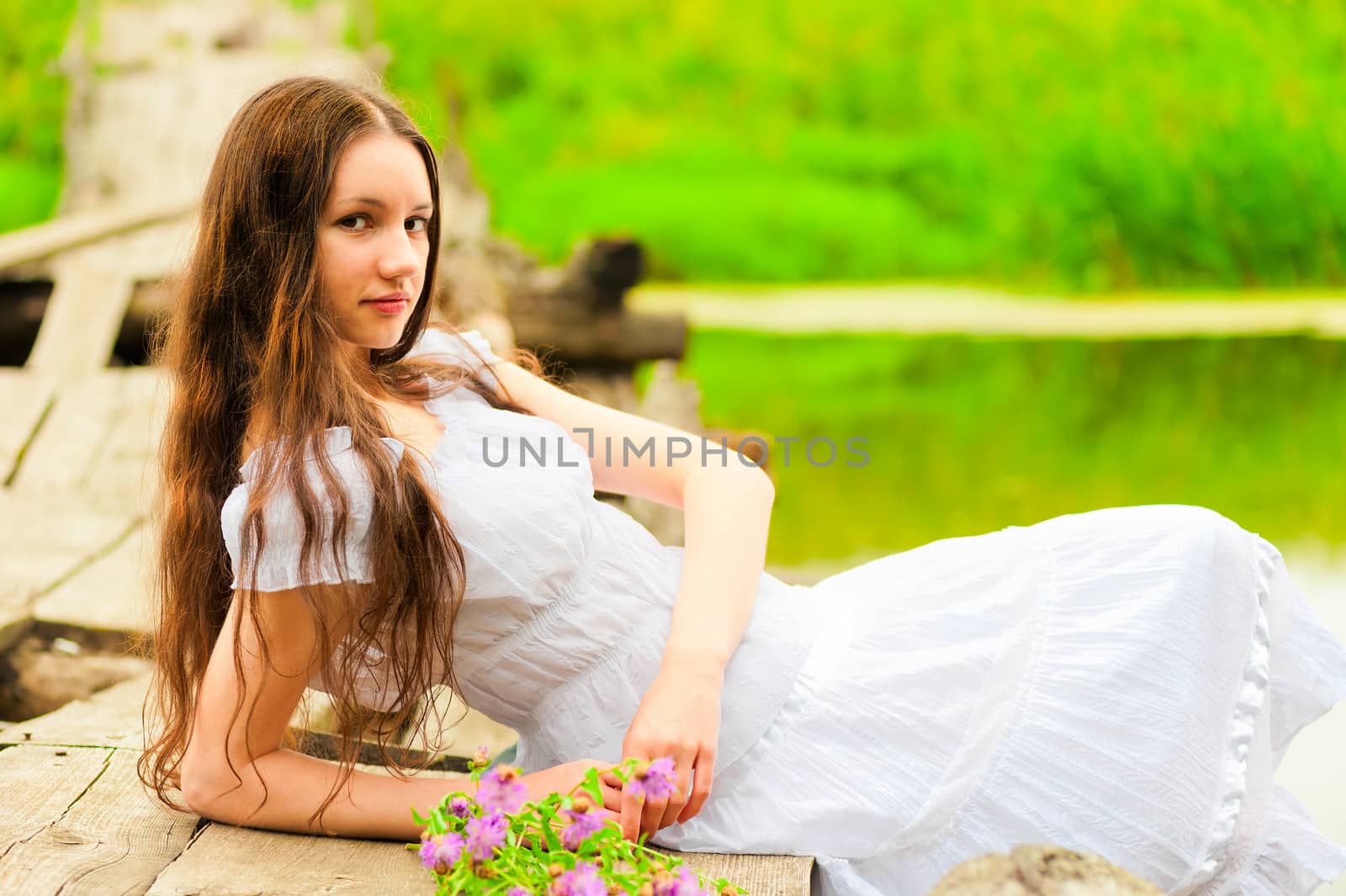 young woman resting on the bridge of the river