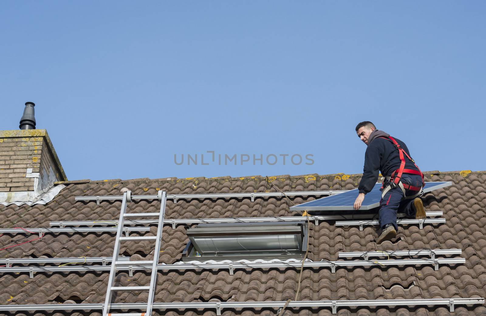 man putting the solar panel to the metal construction on the roof