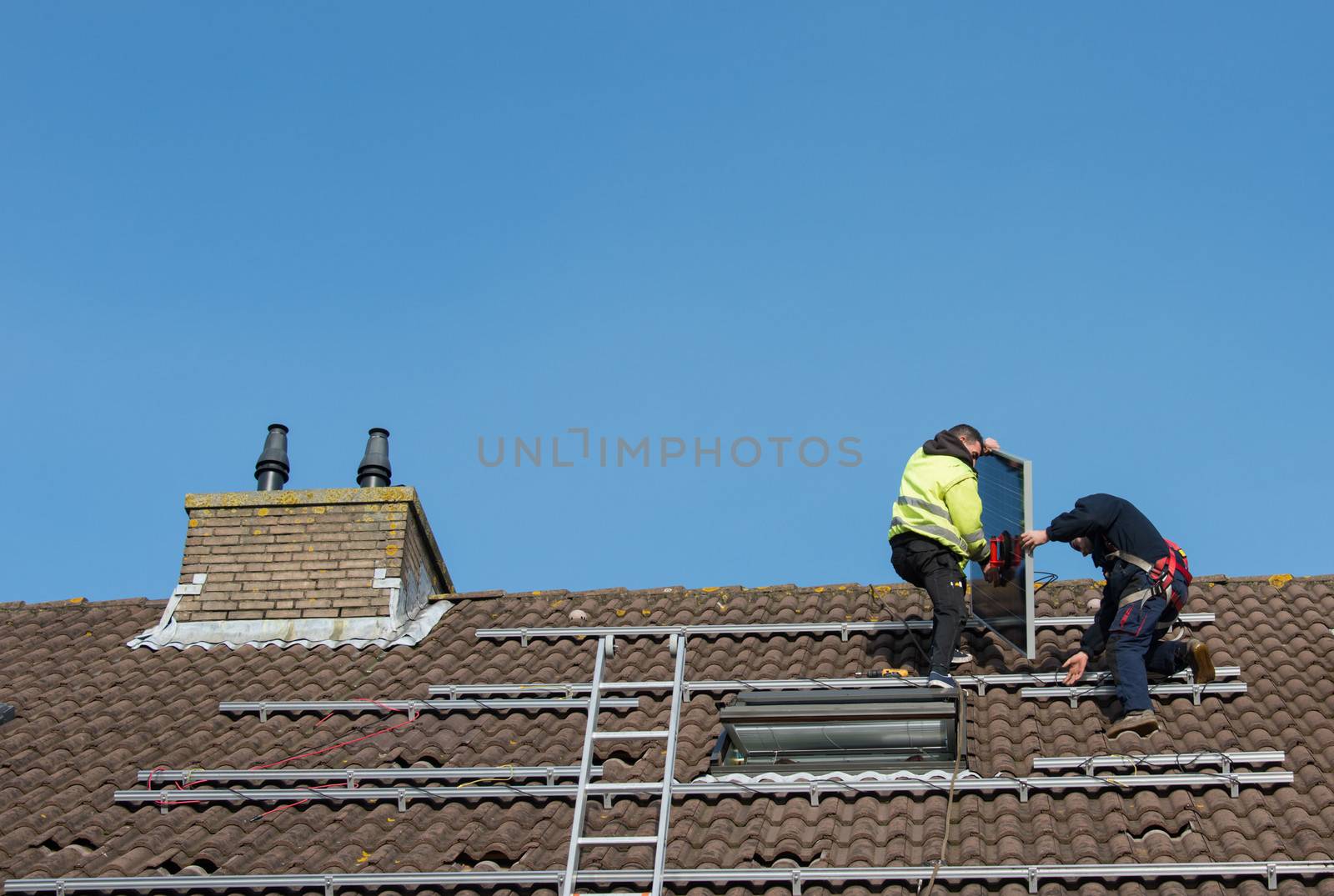 man putting the solar panel on the roof by compuinfoto