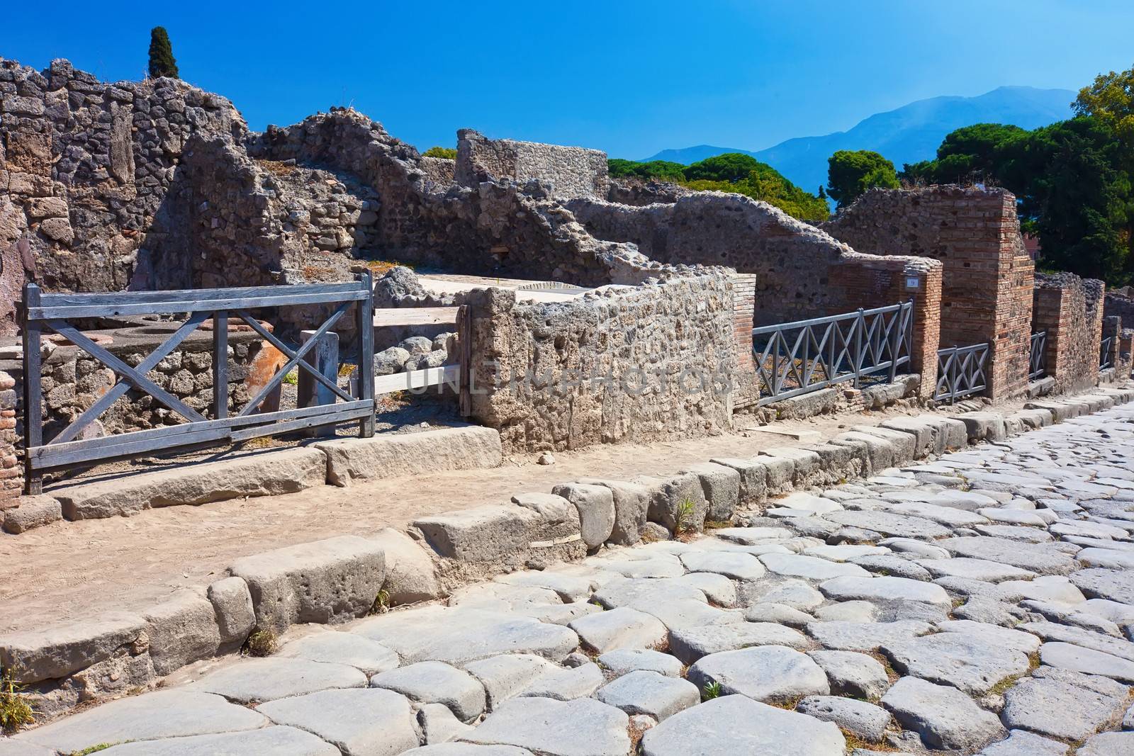 Antique roman stone street through ruins in Pompeii, Italy.