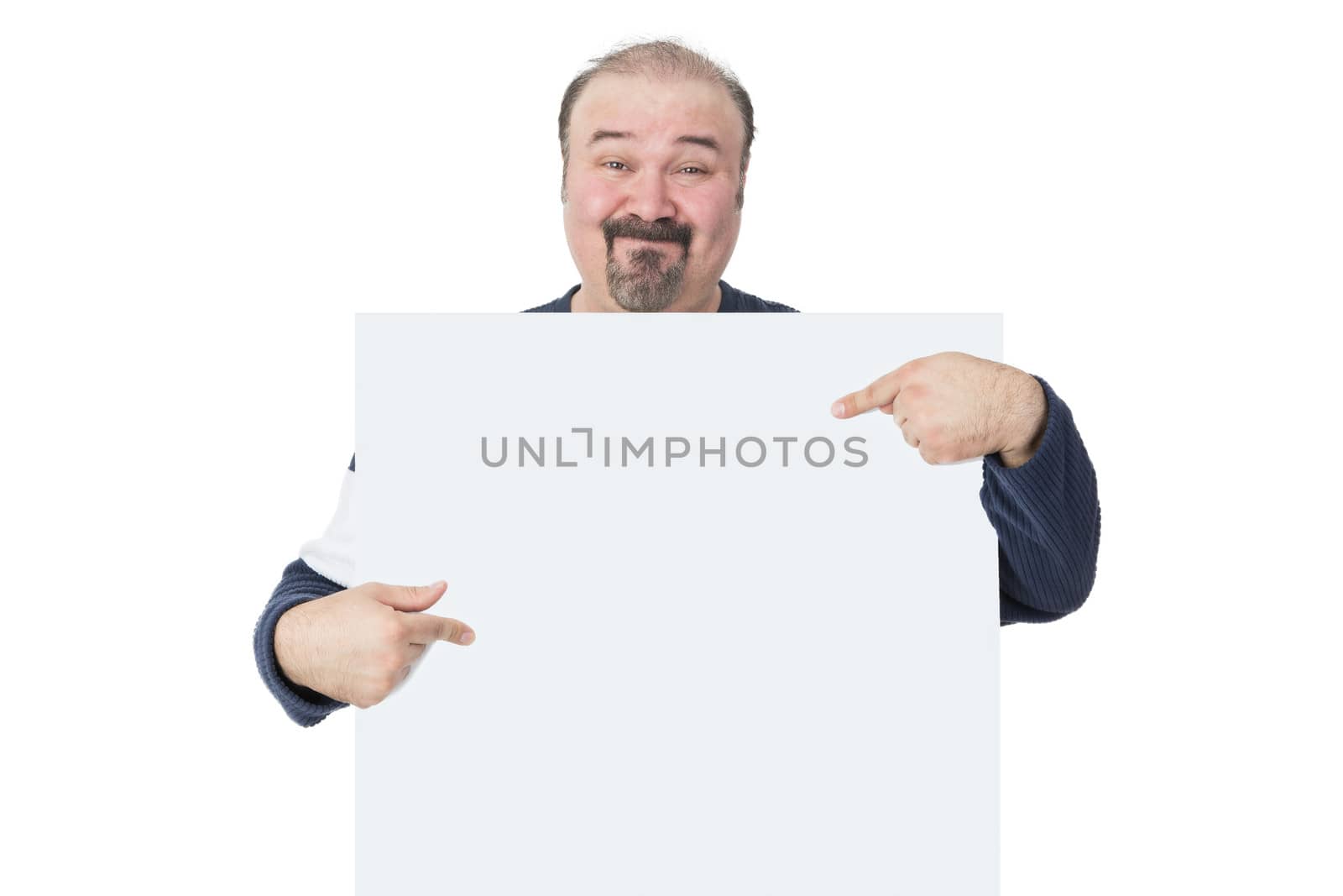 Smiling mature man holding and pointing into a blank billboard