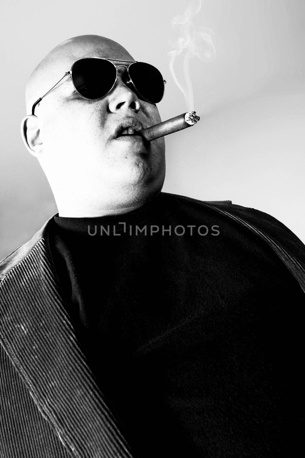Black and white photo of a cigar smoking gangster.  Harsh lighting for more disturbing look.