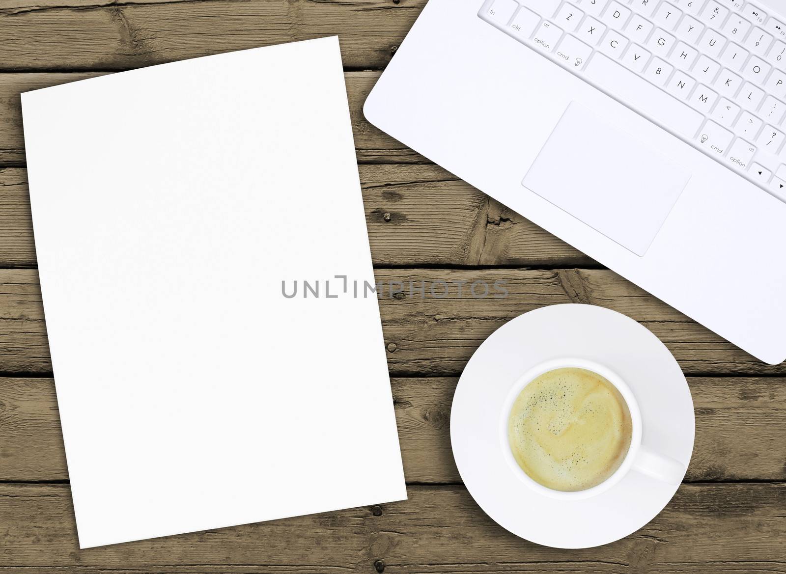 Laptop, paper and cup of coffee with crema on old wooden boards. Computer technology concept