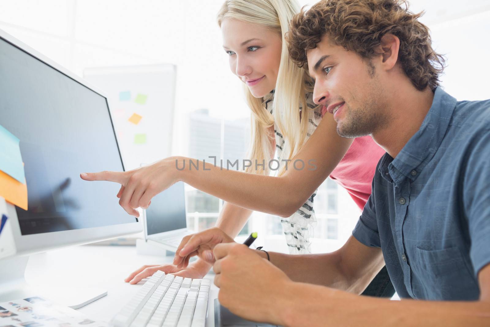 Casual business couple using computer in a bright office