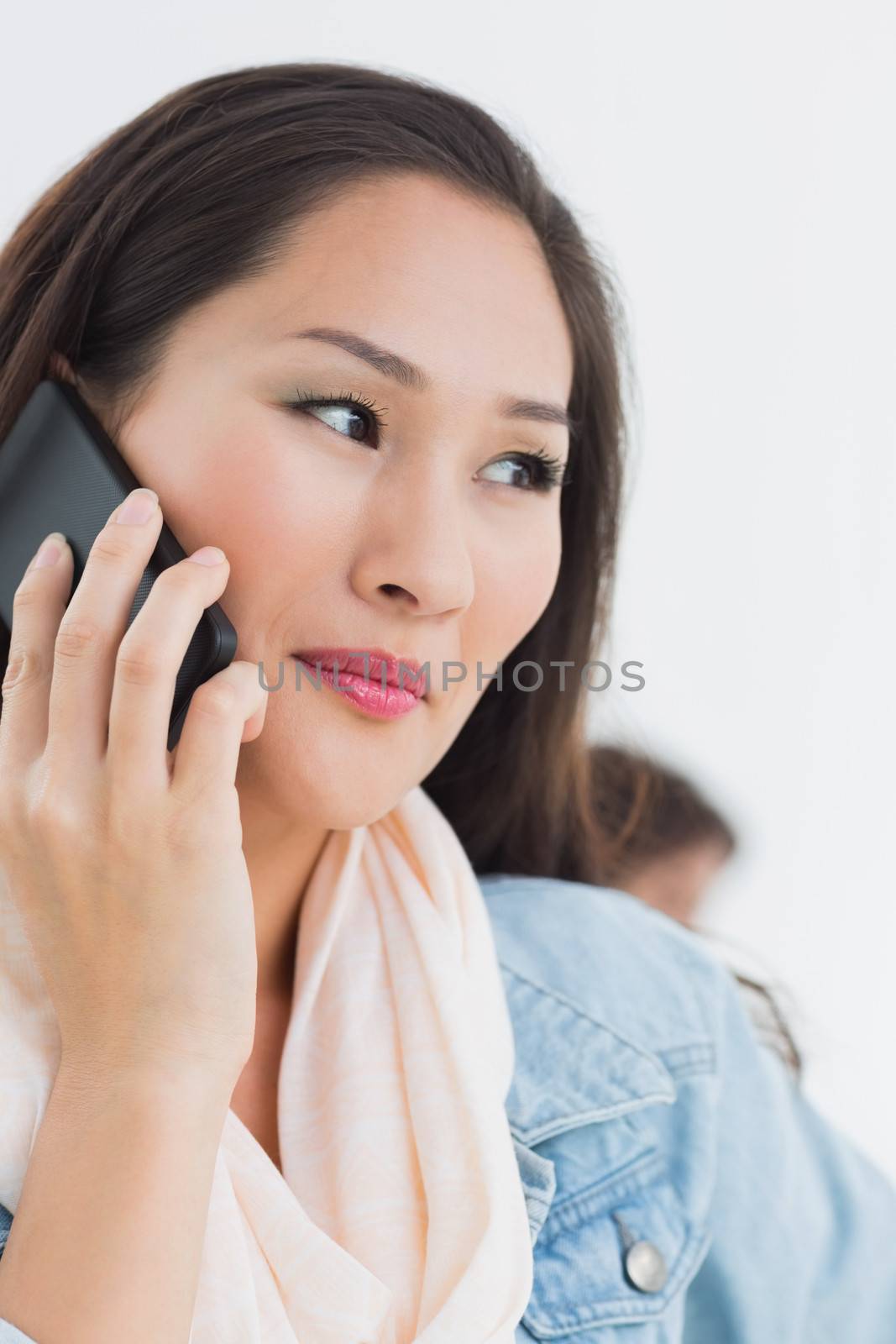 Beautiful casual woman using mobile phone in office by Wavebreakmedia