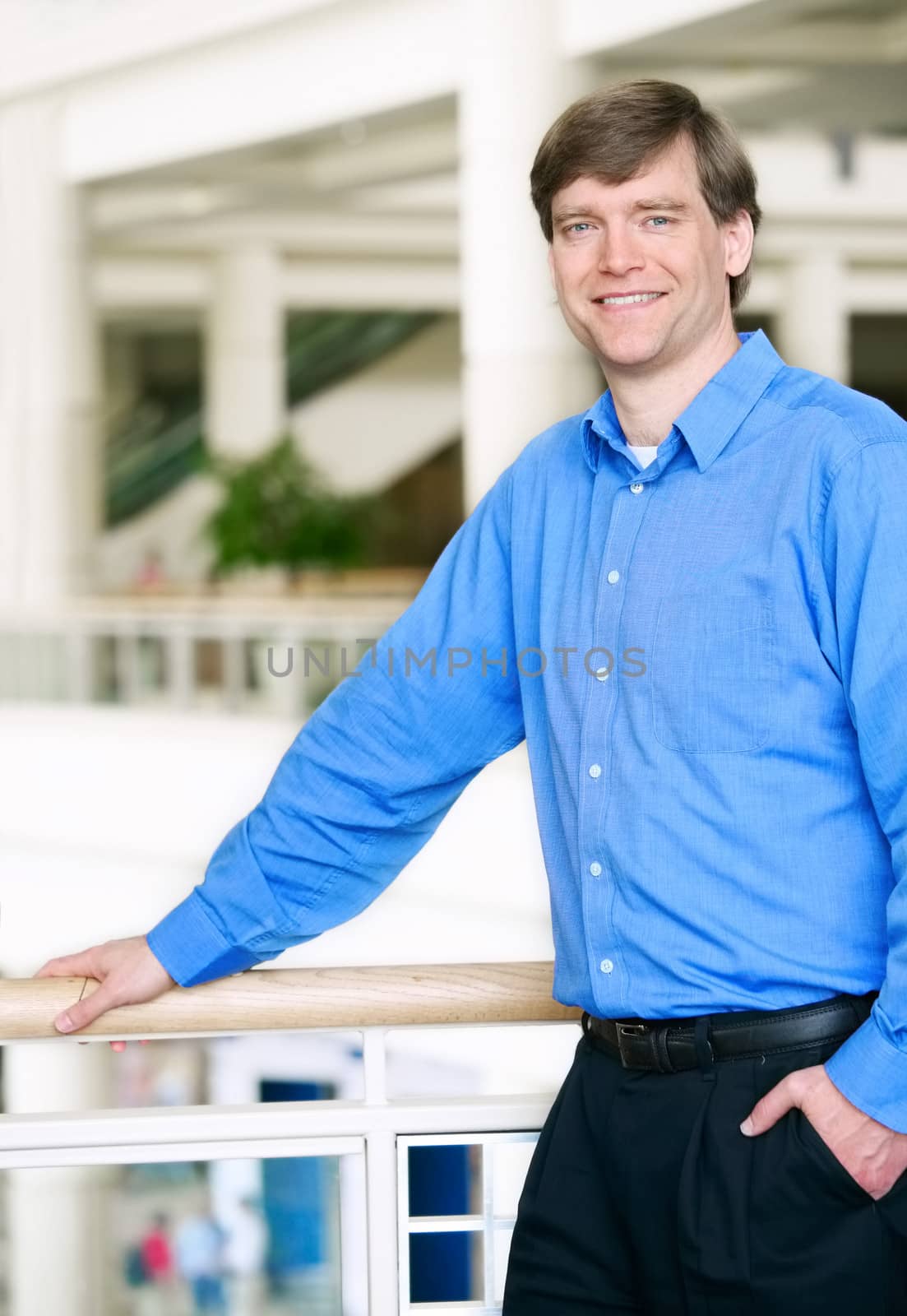 Handsome businessman leaning against railing
