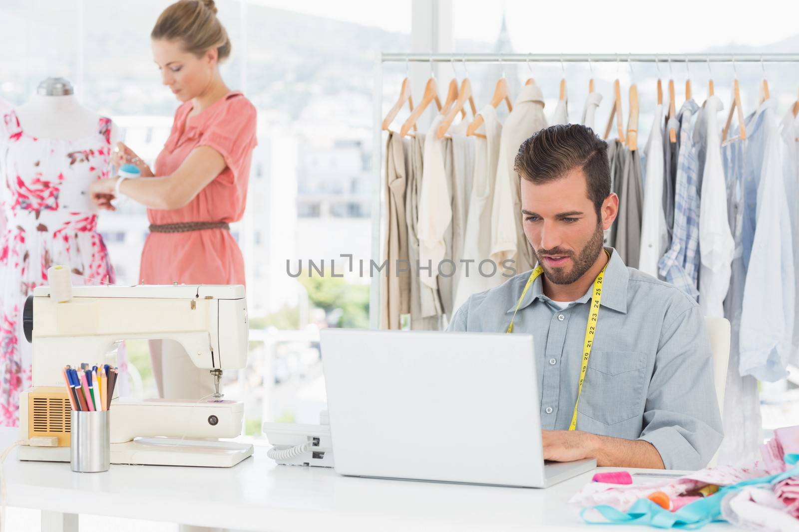 Man using laptop with fashion designer working at studio by Wavebreakmedia