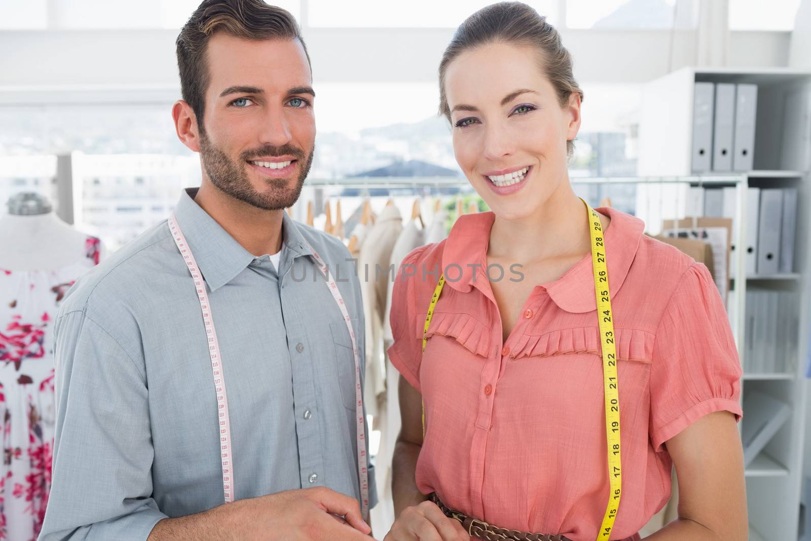 Male and female fashion designers at work in a bright studio