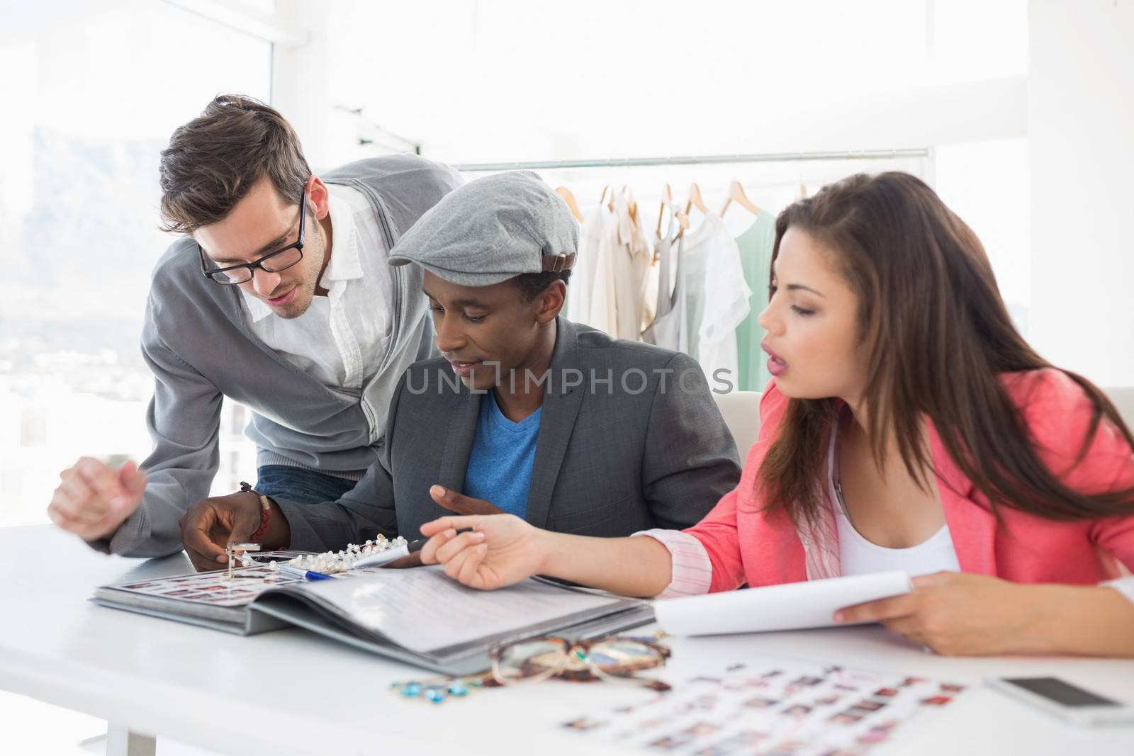 Group of fashion designers discussing designs in a studio