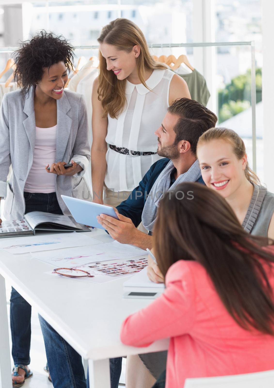 Group of fashion designers discussing designs in a studio
