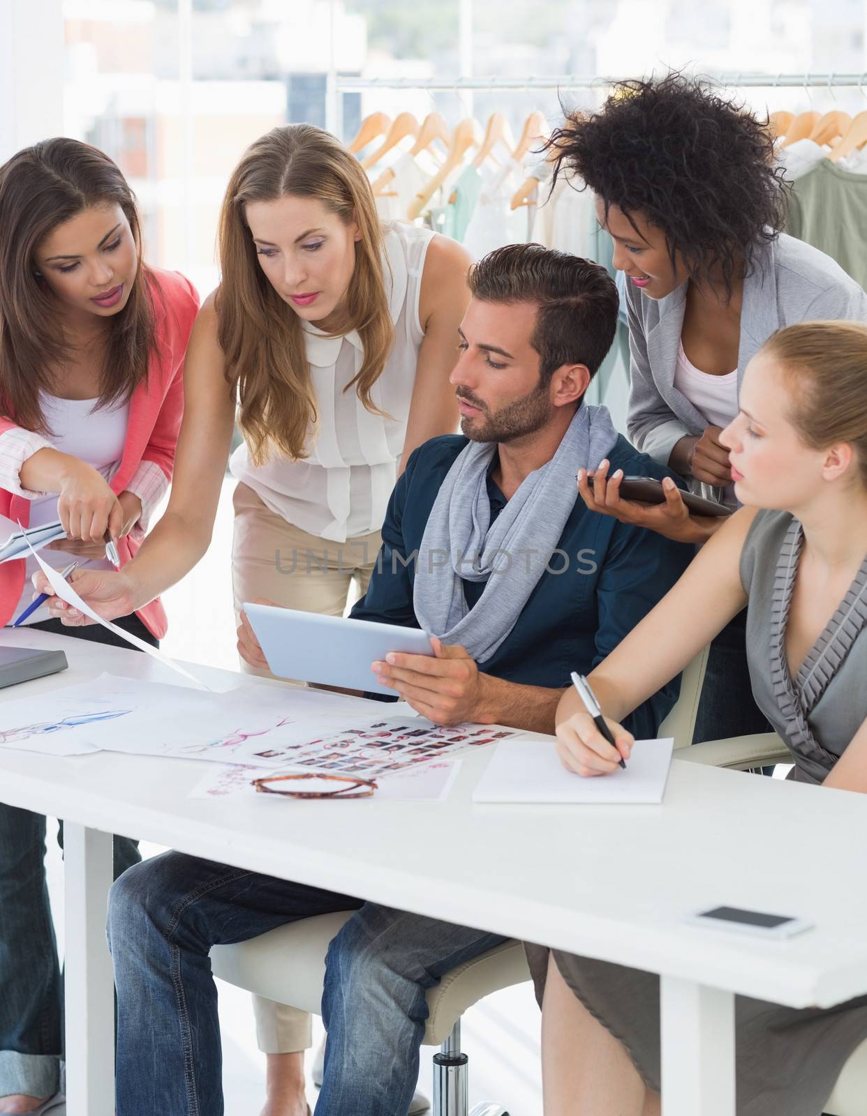 Group of fashion designers discussing designs in a studio