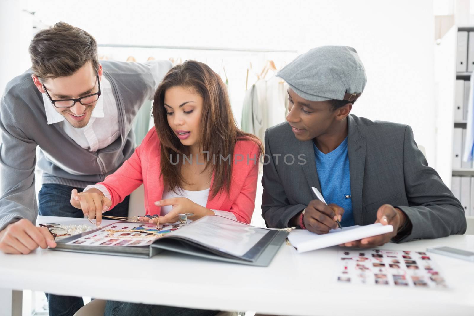 Group of fashion designers discussing designs in a studio