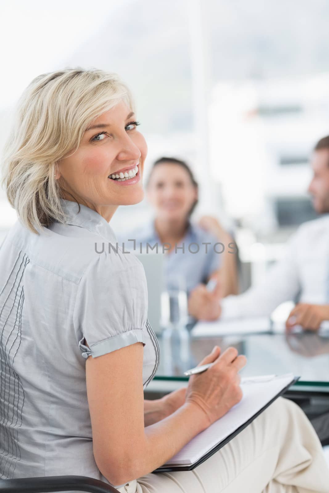Young businesswoman with colleagues discussing in office by Wavebreakmedia