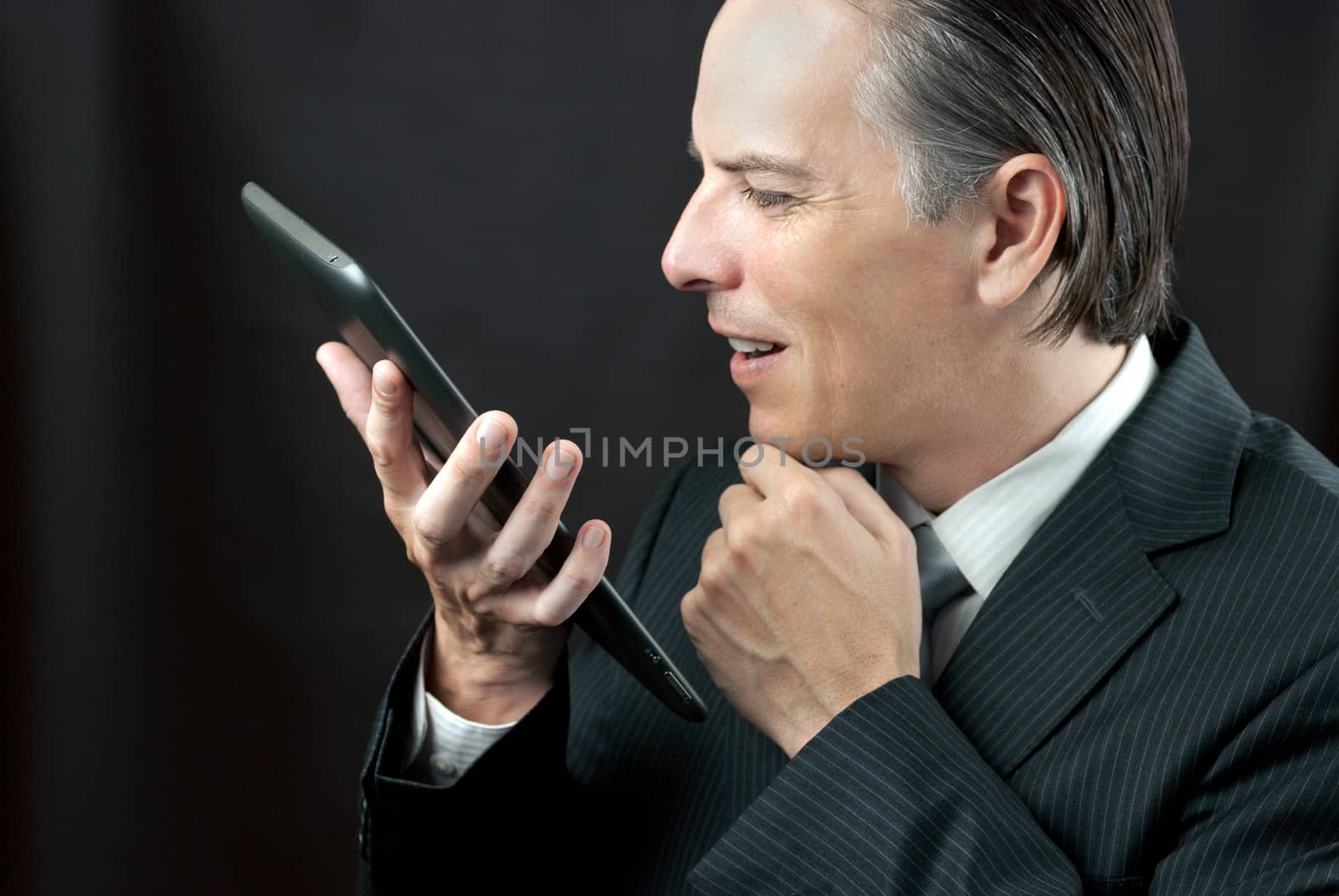 Close-up of a businessman admiring his tablet.