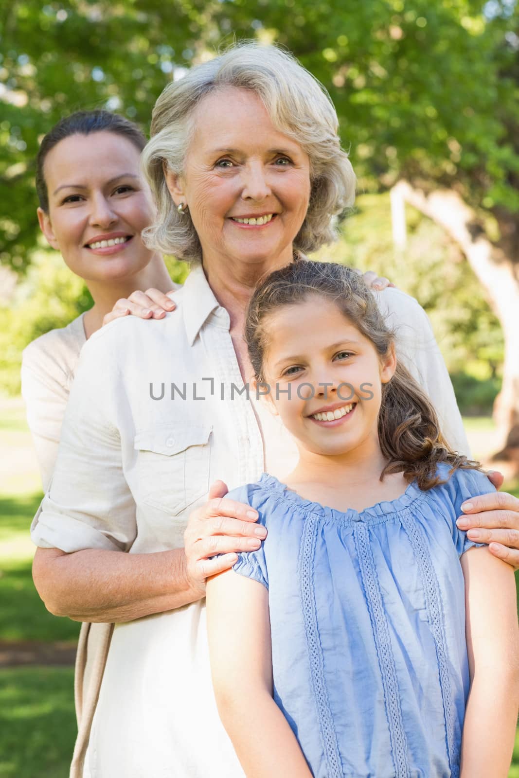 Portrait of a smiling woman with grandmother and granddaughter at the park