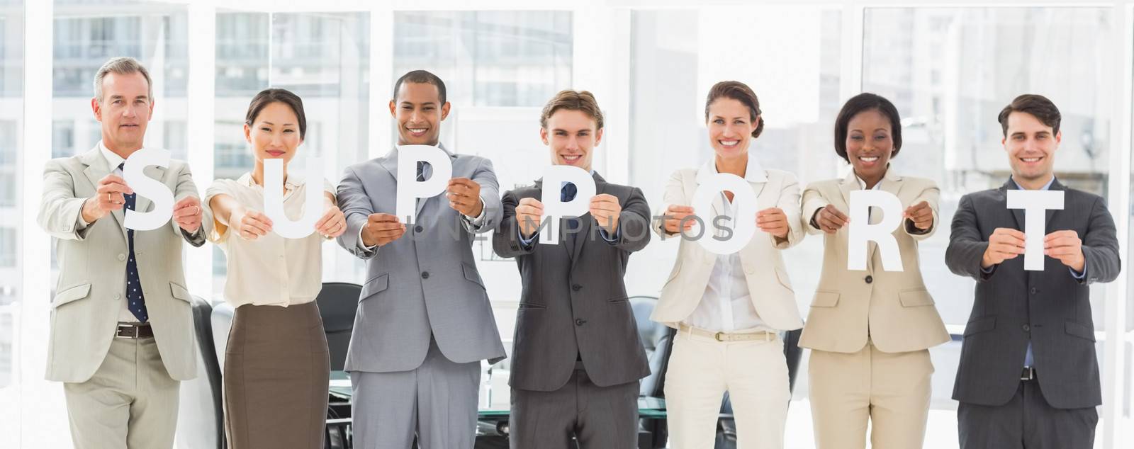 Diverse business team holding up letters spelling support by Wavebreakmedia