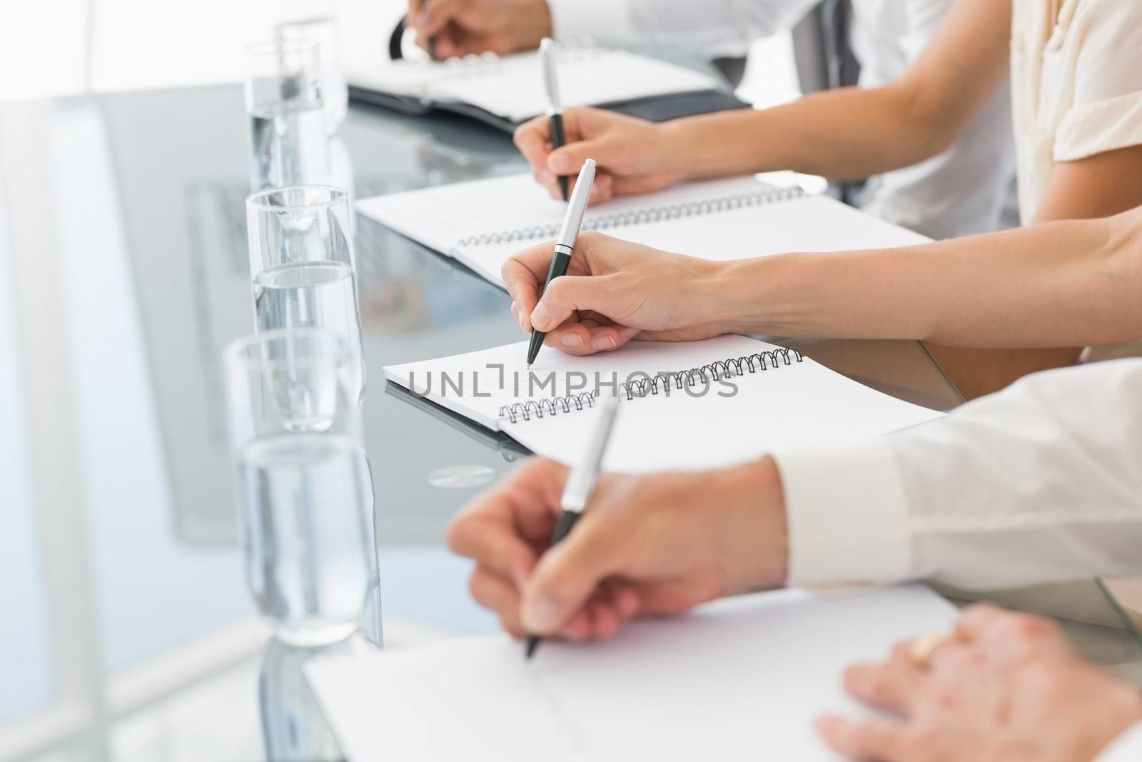 Business people taking down notes at a meeting by Wavebreakmedia