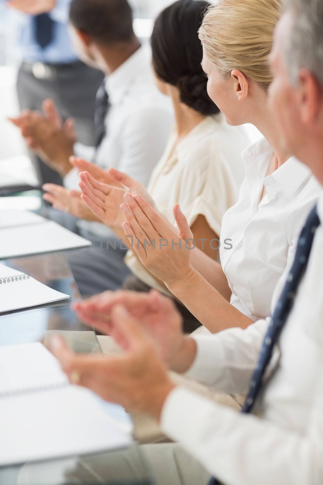 Business people clapping colleague at a meeting by Wavebreakmedia