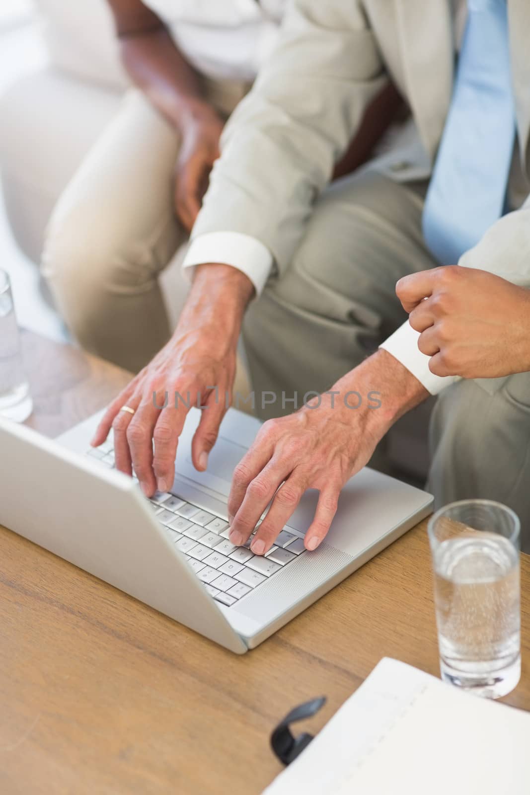 Salesman showing something on laptop to couple in the office