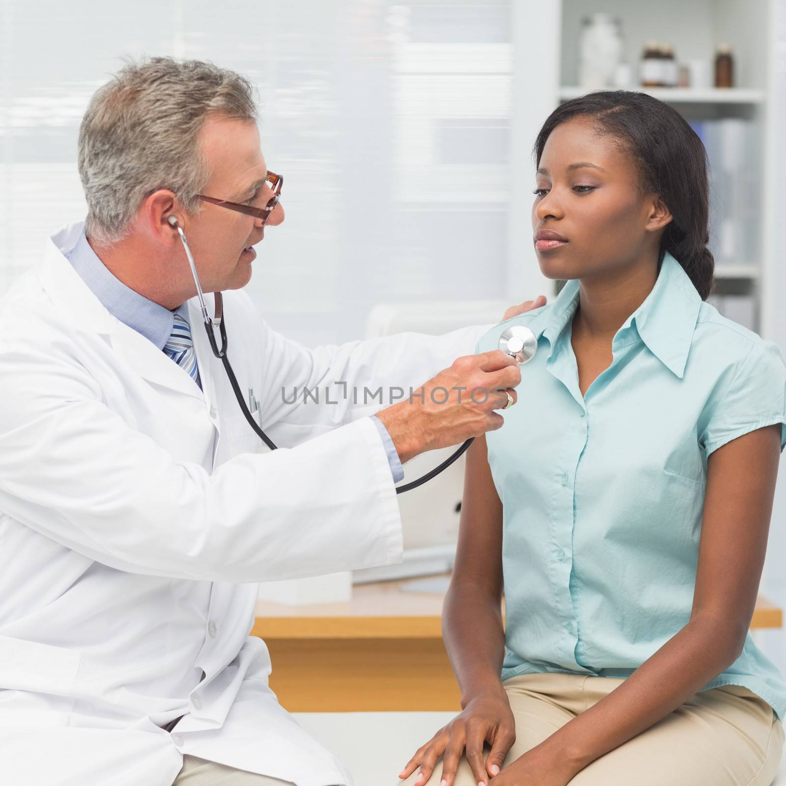 Doctor listening to patients chest with stethoscope by Wavebreakmedia