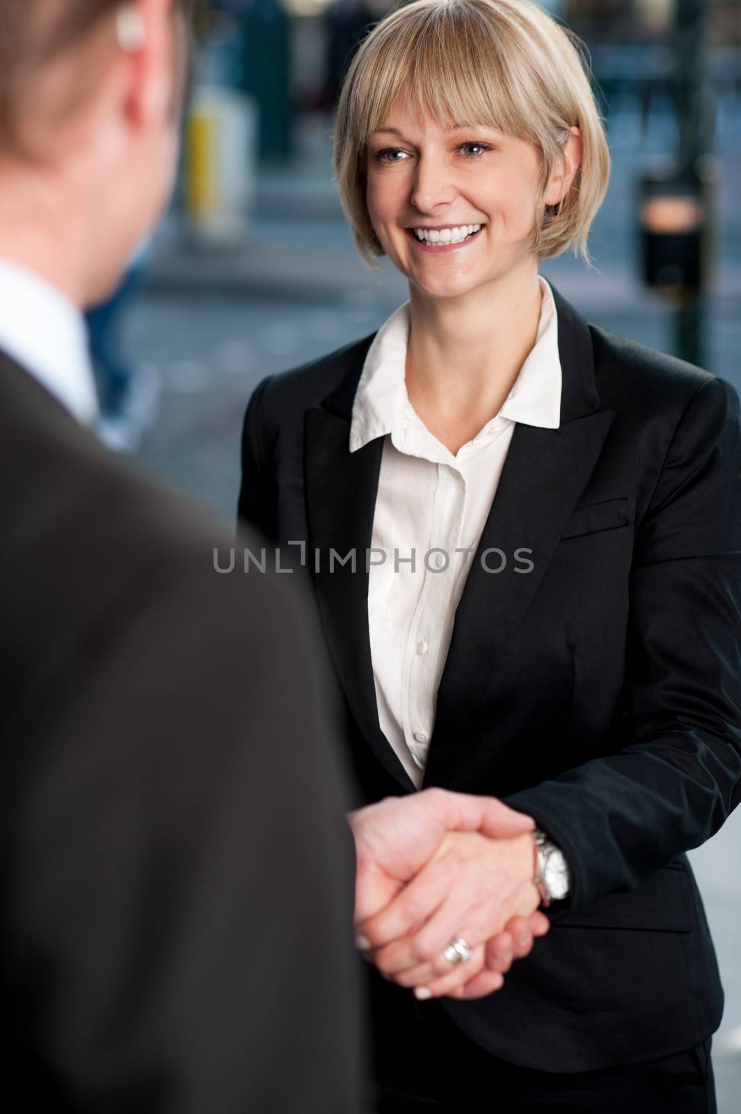 Two corporate identities shaking hands by stockyimages