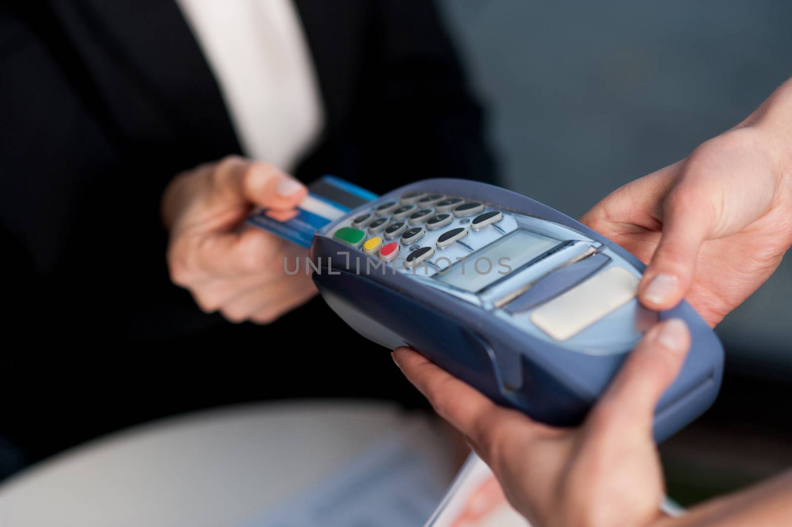 Corporate lady swiping her card to pay by stockyimages
