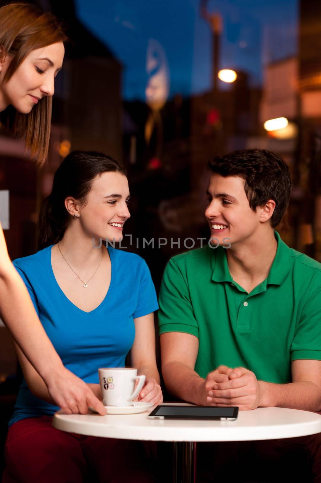 Couple enjoying coffee in cafe by stockyimages