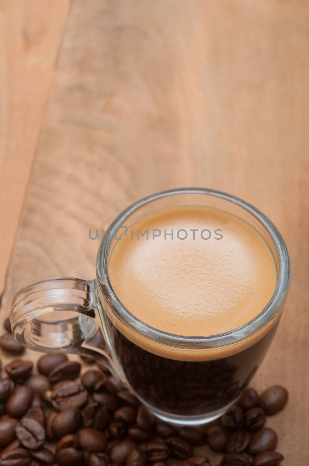 Glass Cup of Espresso Coffee on Wooden Table With Coffee Beans With Copyspace - Shallow Depth of Field